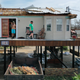 People walk across the deck of a home severely damaged by Hurricane Ida on Aug. 31, 2021 in Montegut, Louisiana.